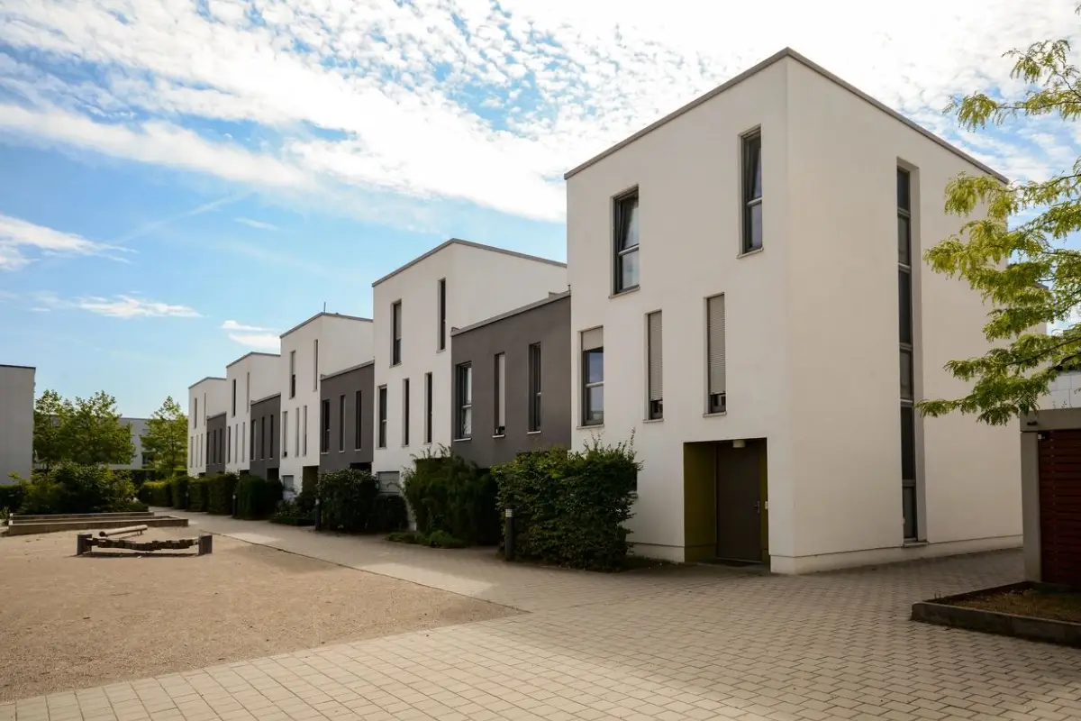 A row of white houses with a sky background