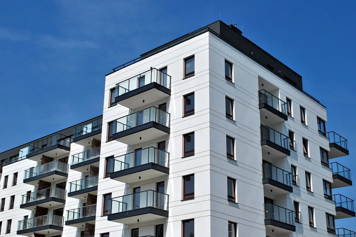 A white building with balconies on the top of it.